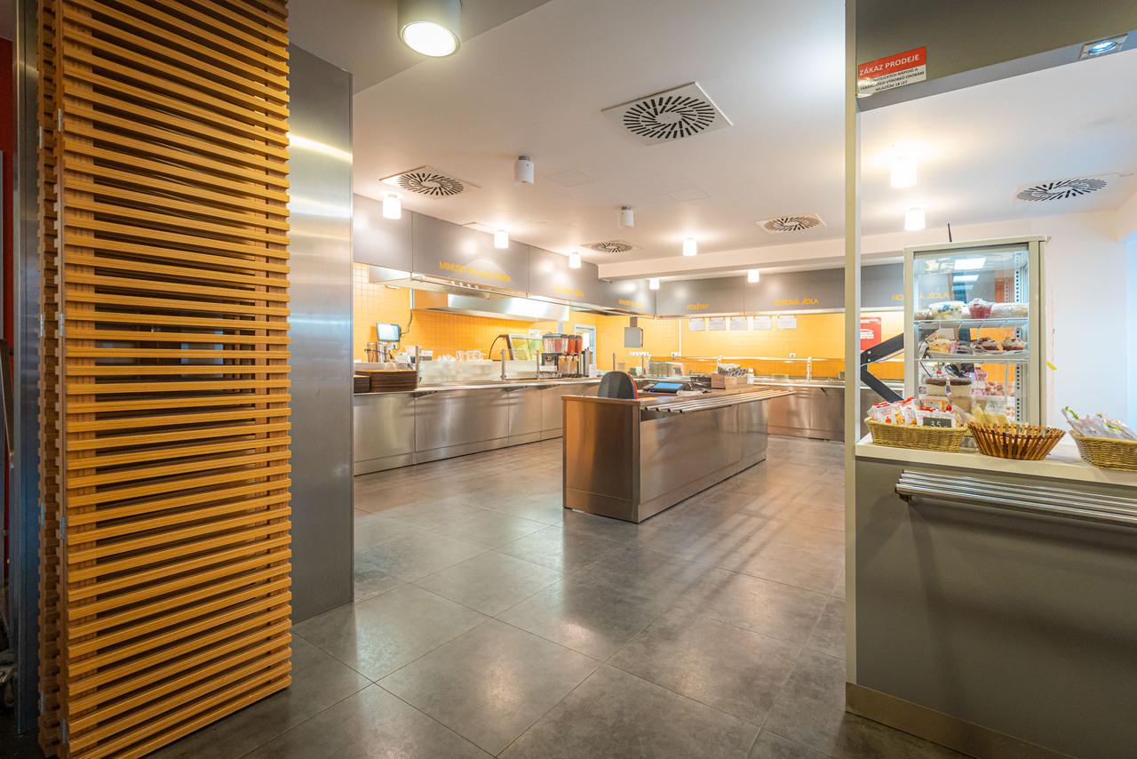 Fotka části jídelny, kde se vydávají pokrmy.