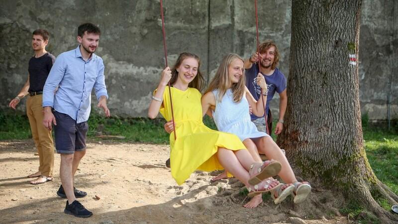 Mladí na houpačkách u kostela sv. Matouše.